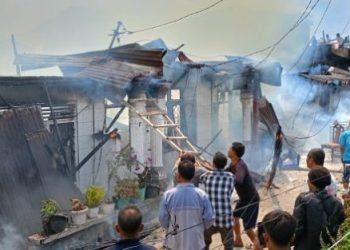 Petugas damkar dibantu warga saat berusaha memadamkan api.