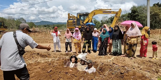 Aksi 'mengubur diri' hidup-hidup sebagai bentuk protes kepada PT Toba Pulp Lestari (TPL).