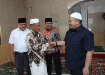 Tapsel Dolly Pasaribu saat menyerahkan bantuan dan zakat mal ke BKM Babussalam, Desa Panindoan, Kecamatan Tano Tombangan Angkola, Minggu (7/4). (IST)