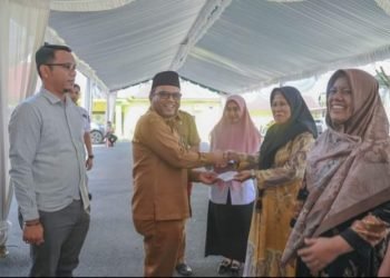 Pj. Wali Kota Padangsidimpuan Letnan Dalimunte saat menyerahkan tali asih pada Anggota Korpri. (IST)