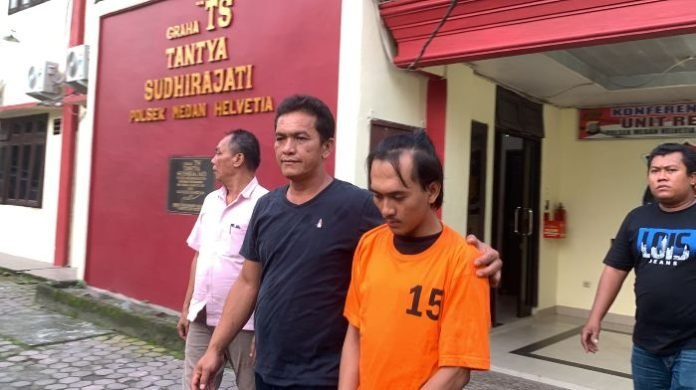 Tersangka MA (pakai baju tahanan) saat digiring di Polsek Medan Helvetia. 
