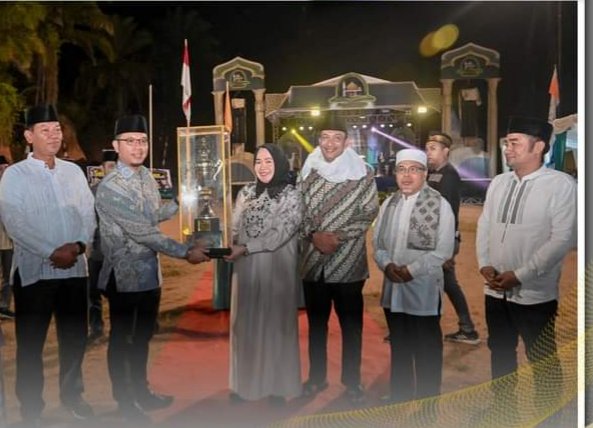 Plt. Sekretaris Daetah Kota Padangsidimpuan, Roni Gunawan Rambe,menyerahkan piala Camat Padangsidimpuan utara Nanda Alvina.SH yang keluar sebagai juara umum MTQ XXIII Kota Pàdangsidimpuan. (IST)