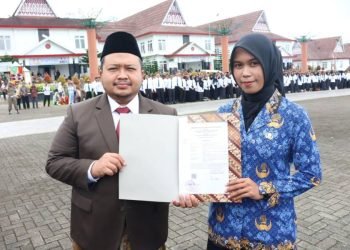 Photo :Bupati Tapsel Dolly Pasaribu menyerahkan SK PNS lulusan Sekolah Tinggi Transportasi Darat (STTD)  secara simbolis usai Perinfatan Hardiknas. (IST)