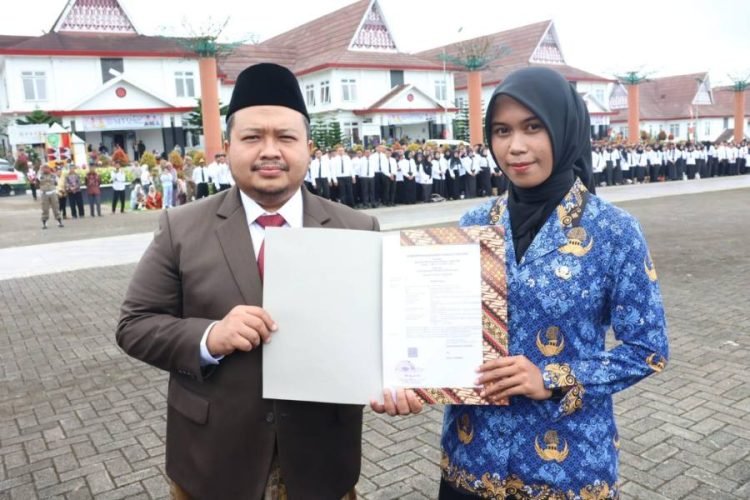 Photo :Bupati Tapsel Dolly Pasaribu menyerahkan SK PNS lulusan Sekolah Tinggi Transportasi Darat (STTD)  secara simbolis usai Perinfatan Hardiknas. (IST)