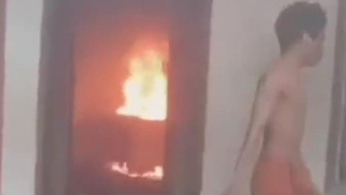 Tangkapan layar video seorang pria membakar rumahnya sendiri karena diduga kecanduan narkoba.