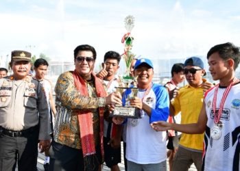 Bupati Samosir menyerahkan piala kepada tim Siogungogung. (Suriono)