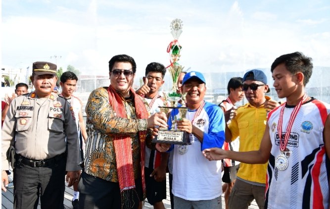 Bupati Samosir menyerahkan piala kepada tim Siogungogung. (Suriono)