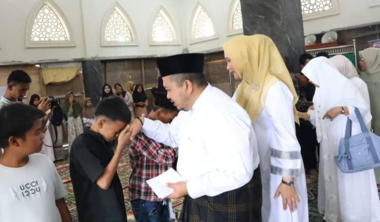 Bupati Tapsel Dolly dan keluarga saat memberikan santunan bagi puluhan anak yatim. (IST)