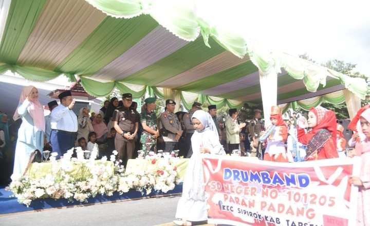 Bupati Dolly Pasaribu bersama Ketua TP PKK Tapsel Ny. Rosalina Dolly Pasaribu beri hormat pada peserta pawai Taruf MTQ ke-39 Tingkat Provsu di Sipirok. (IST)