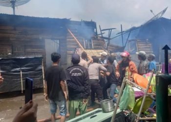 Personel Damkar dan warga setempat saat memadamkan api.