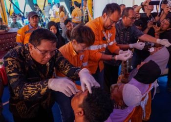Direktur dan CEO PT AR  Noviandri (dua dari kanan) meneteskan obat tetes mata pada pada pasien operasi katarak gratis di Puskesmas Batang toru, Jumat ( 26/7). (IST)