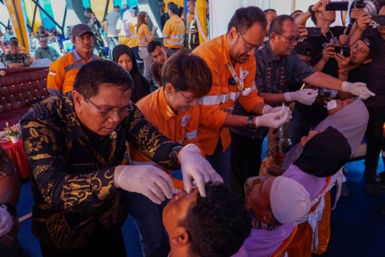 Direktur dan CEO PT AR  Noviandri (dua dari kanan) meneteskan obat tetes mata pada pada pasien operasi katarak gratis di Puskesmas Batang toru, Jumat ( 26/7). (IST)