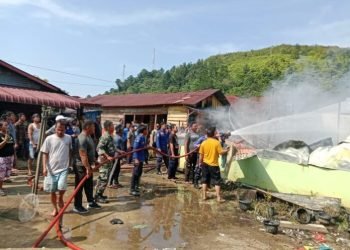 Warga dan petugas Damkar berupaya memadamkan api.