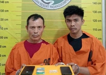 Kedua pelaku saat diamankan di kantor polisi. 