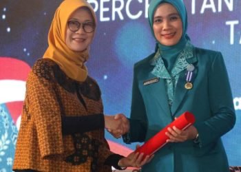 Deputi Bidang Koordinasi Peningkatan Kualitas Anak, Perempuan dan Pemuda Kemenko PMK Woro Srihastuti S saat menyerahkan penghargaan pada Ketua TP PKK Tapanuli Selatan, Ny Rosalina Dolly Pasaribu di Merapi Grand Ballroom Kota Semarang, Jumat (28/6). (IST)