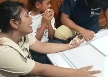 Putri bungsu Ramces Manulang menangis di depan peti mati bapak dan kelima saudaranya. 