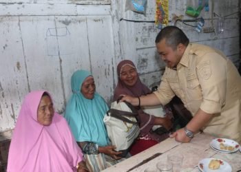 Bupati Tapsel Dolly Pasaribu memberikan sembako pada lansia dan warga rentan ekonomi saat berkunjung ke Arse. (IST)