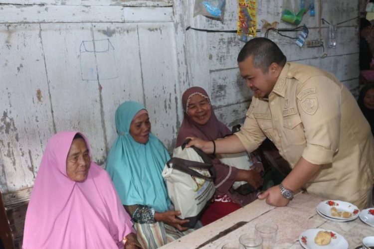 Bupati Tapsel Dolly Pasaribu memberikan sembako pada lansia dan warga rentan ekonomi saat berkunjung ke Arse. (IST)