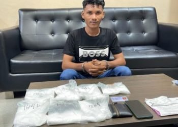 Maulana Afrizal bersama barang bukti 7 bungkus sabu yang dibawanya. 