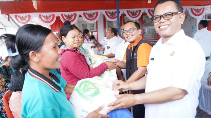 Bupati Toba Poltak Sitorus berfoto dengan penerima Bantuan Cadangan Pangan Beras di Kecamatan Laguboti. (IST)