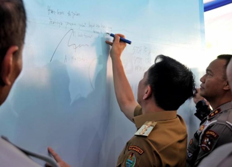 Pj Gubernur Agus Fatoni bersama Tim Pembina Samsat Tingkat Nasional menandatangani Gerakan 1.000 Tanda Tangan Pencanangan Tertib di Jalan dalam rangka menyambut PON XXI Aceh – Sumut di  Lapangan Astaka Jalan William Iskandar, Kec. Percut Sei Tuan, Kab. Deliserdang, Sabtu (3/8/2024). (Diskominfo Sumut)