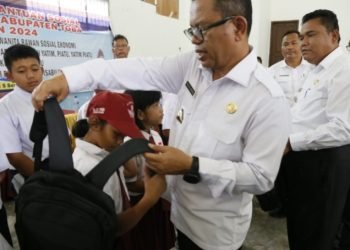 Bupati Toba Poltak Sitorus berikan tas ransel kepada anak sekolah yatim piatu. (IST)