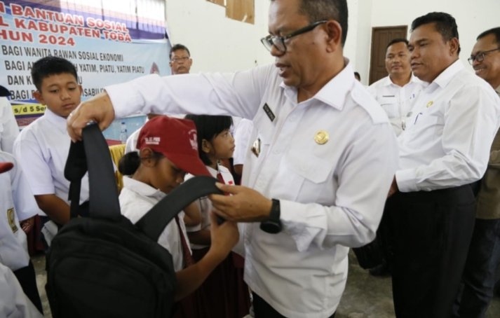 Bupati Toba Poltak Sitorus berikan tas ransel kepada anak sekolah yatim piatu. (IST)