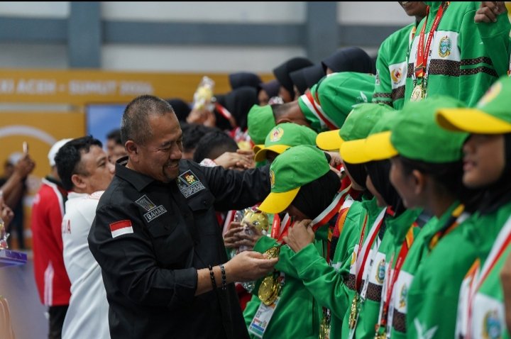 Ketua FDBI Sumatera Utara, Baharuddin Siagian menyalami Tim Drumband Sumut usai berhasil menambah pundi medali emas PON XXI Aceh-Sumut 2024 dari nomor LBJP 600 meter campuran. (PB PON)