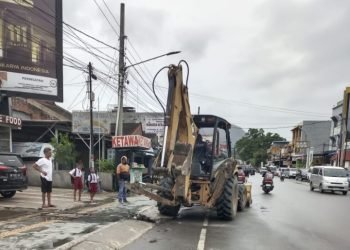 Dinas PUPR Pemkab Toba menurunkan alat berat untuk membersihkan parit di Kota Balige. (IST)