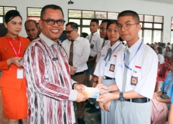Bupati Toba Poltak Sitorus memberikan bantuan secara simbolis kepada siswa berprestasi dan anak yatim piatu. (IST)