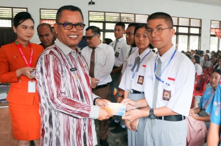 Bupati Toba Poltak Sitorus memberikan bantuan secara simbolis kepada siswa berprestasi dan anak yatim piatu. (IST)