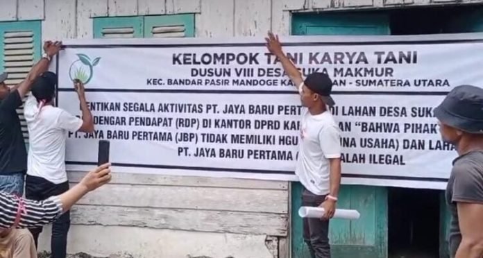 Masa kelompok tani menyegel kantor perkebunan dalam aksi unjuk rasa.