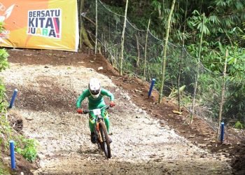 Pembalap MTB putra Jawa Tmur Pandu Satrio Perkasa setelah melewati jumping down dan melaju dengan kecepatan penuh menuju finish di lintasan MTB Arena Tahura Bukit Barisan-Karo, Minggu (8/9/2024) (Foto: PB PON XXI SUMUT/A. ENDRO RUSHARYANTO)