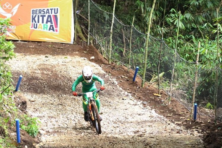 Pembalap MTB putra Jawa Tmur Pandu Satrio Perkasa setelah melewati jumping down dan melaju dengan kecepatan penuh menuju finish di lintasan MTB Arena Tahura Bukit Barisan-Karo, Minggu (8/9/2024) (Foto: PB PON XXI SUMUT/A. ENDRO RUSHARYANTO)