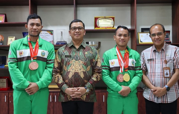 Pjs Bupati Toba Agustinus Panjaitan foto bersama dengan atlet karate peraih Medali Emas Pon XXI Aceh - Sumut. (IST)