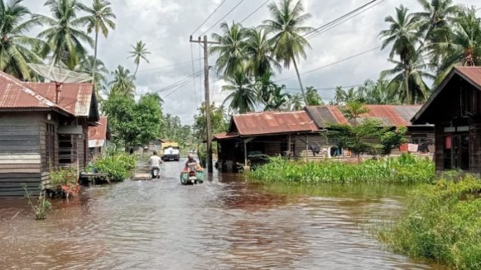 Aktivitas warga di Desa Pematang Sei Baru terganggu akibat banjir.
