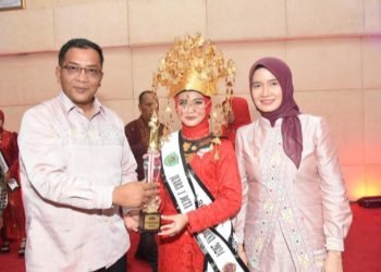 Plt. Bupati Tapsel Rasyid Assaf Dongoran dan Plt. Ketua TP. PKK Sri Rezeki Rasyid Assaf Dongoran menyerahkan piala ke"Boru Namora" 2024 Tapsel. (IST)