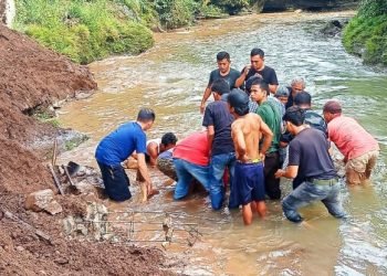Warga kelurahan Wek IV sedang melakukan evakuasi korban longsor.