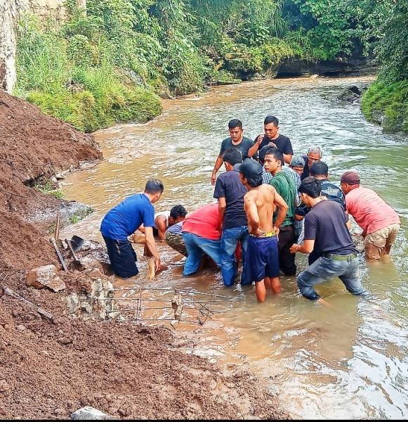 Warga kelurahan Wek IV sedang melakukan evakuasi korban longsor.