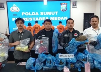 Polisi memperlihatkan barang bukti ganja yang disita dari lima tersangka. 