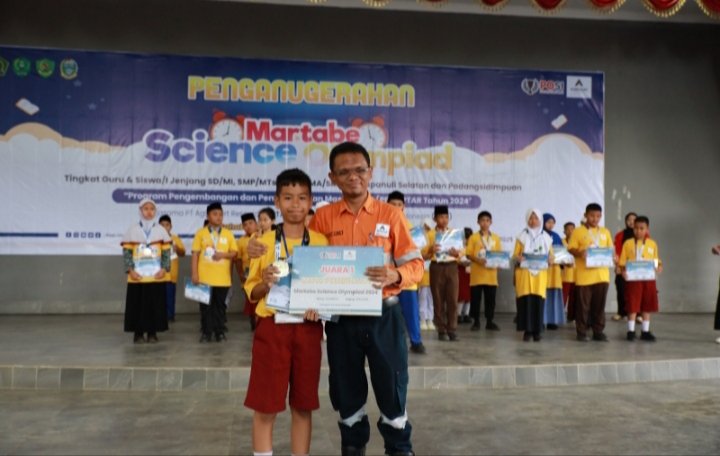 General Manager dan Deputy Director Operations  PT.AR Rahmat Lubis foto bersama dengan salah satu penerima penghargaan latar belakang peserta penerima penghargaaan peserta Martabe Science Olympiade 2024 di Dopo Daganak Batang Toru Tapsel. (IST)
