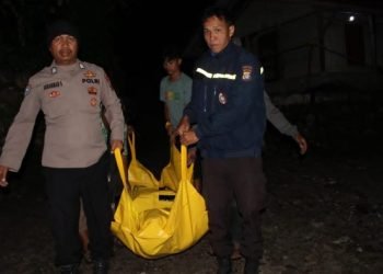 Petugas membawa jasad korban. 