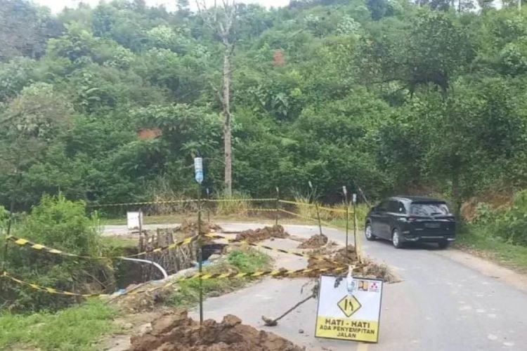 Separoh badan ruas Jalan Lintas Sumatera di daerah Batu Jomba, Kabupaten Tapanuli Selatan yang amblas.