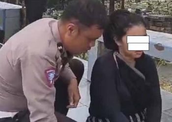 Personel Ditlantas Polda Sumut menenangkan IRT yang hendak bunuh diri terjun dari Fly Over Amplas, Rabu (19/3/2025). 