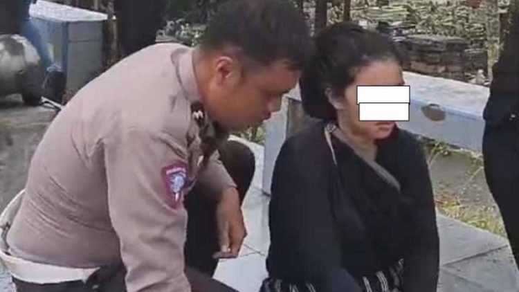 Personel Ditlantas Polda Sumut menenangkan IRT yang hendak bunuh diri terjun dari Fly Over Amplas, Rabu (19/3/2025). 