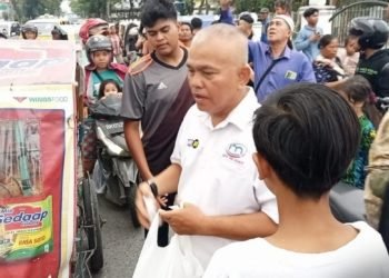 Ketua IMO Sumut saat membagikan takjil kepada pengendara yang melintas di depan  Taman Makam Pahlawan. (IST)
