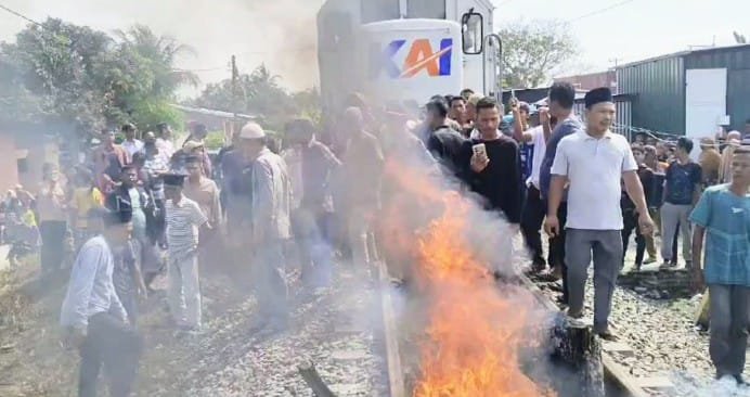 Warga memblokir lintasan sehingga KA tidak dapat melanjutkan perjalanannya. 