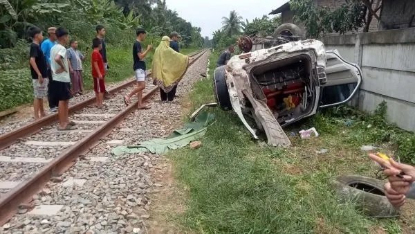 Kondisi mobil yang terbalik usai ditabrak KA. 