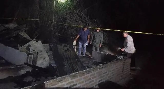 Petugas melakukan olah TKP di lokasi pembakaran rumah.