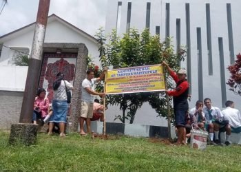 Keturunan Tarpuar Napitupulu pasang spanduk permintaan tanahnya untuk dikembalikan Yayasan TB Soposurung, Balige, Rabu (9/4/2025). 